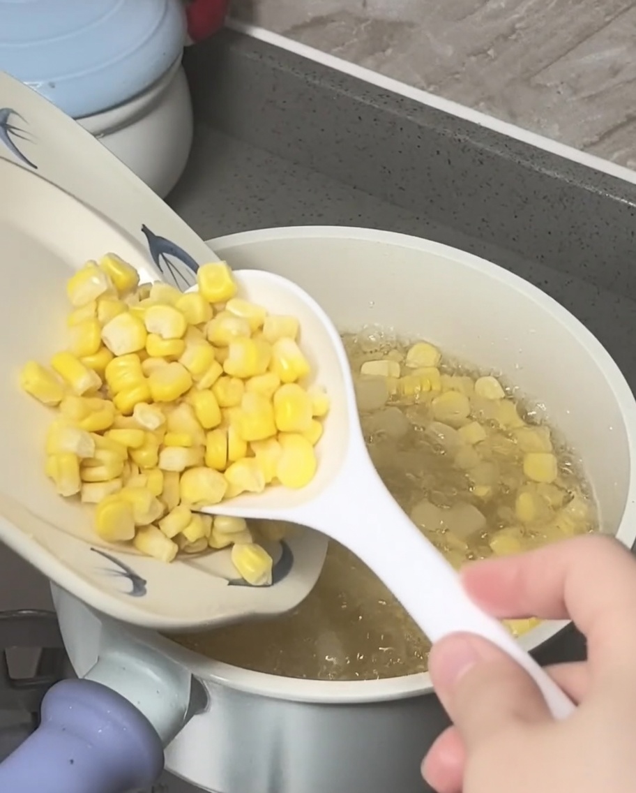 끓는 설탕물 냄비에 옥수수 알갱이와 찧은 물밤을 넣는 모습.