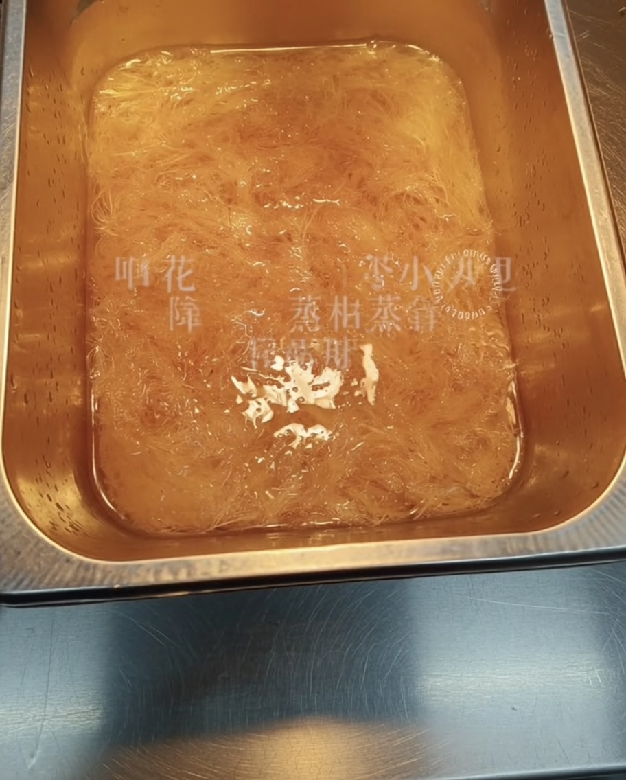 용기에 담긴 물에 말린 실 모양의 우뭇가사리를 넣어 불리는 클로즈업 모습.