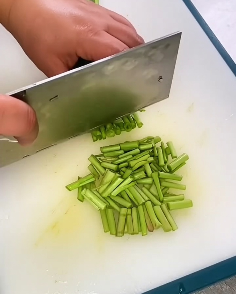 도마 위에 쌓여 있는 싱싱한 부추 조각.