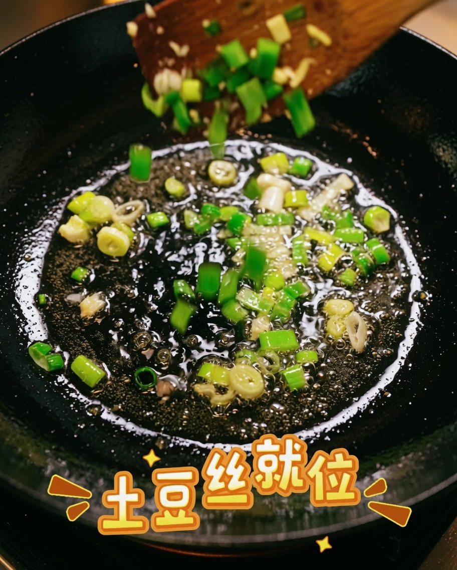 팬에 담긴 파기름에 채 썬 감자를 넣고 함께 섞으며 볶는 모습.
