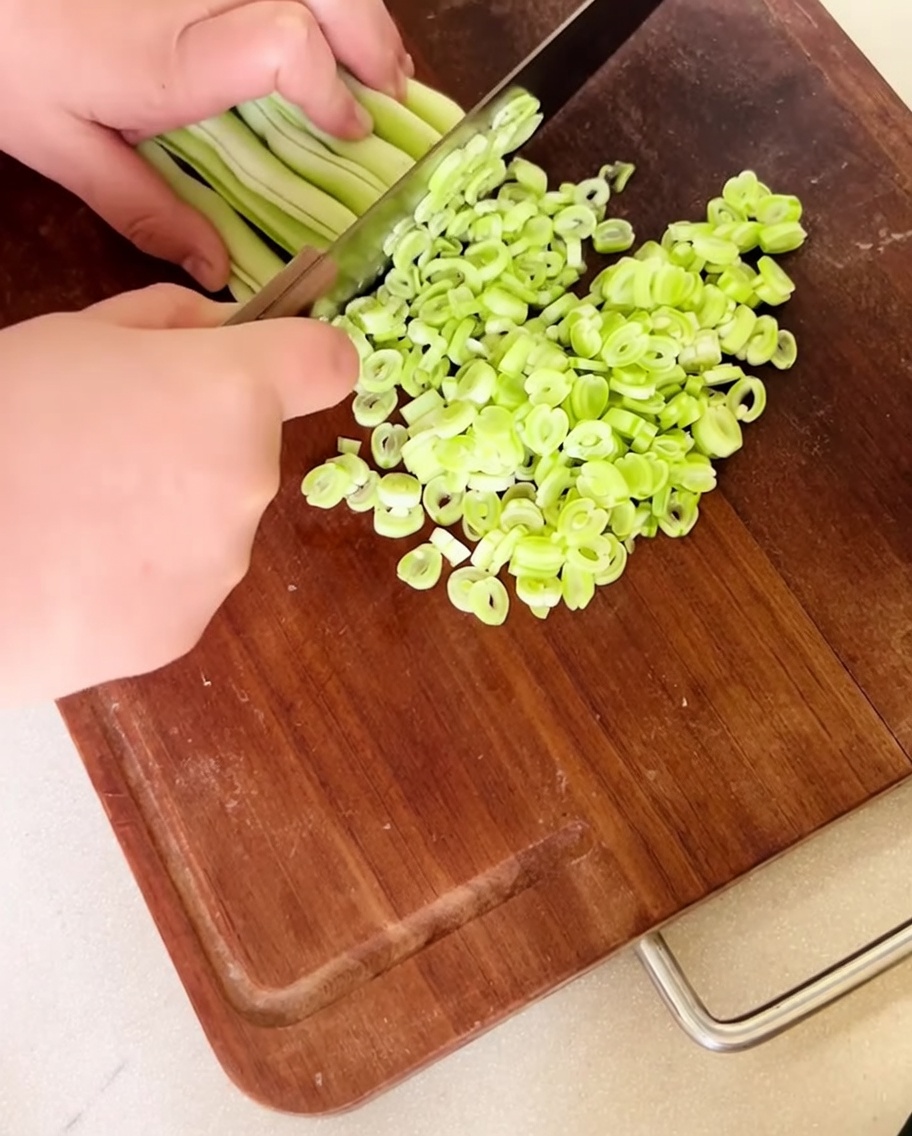 나무 도마 위에 잘게 썬 생강낭콩이 펼쳐져 있는 모습.