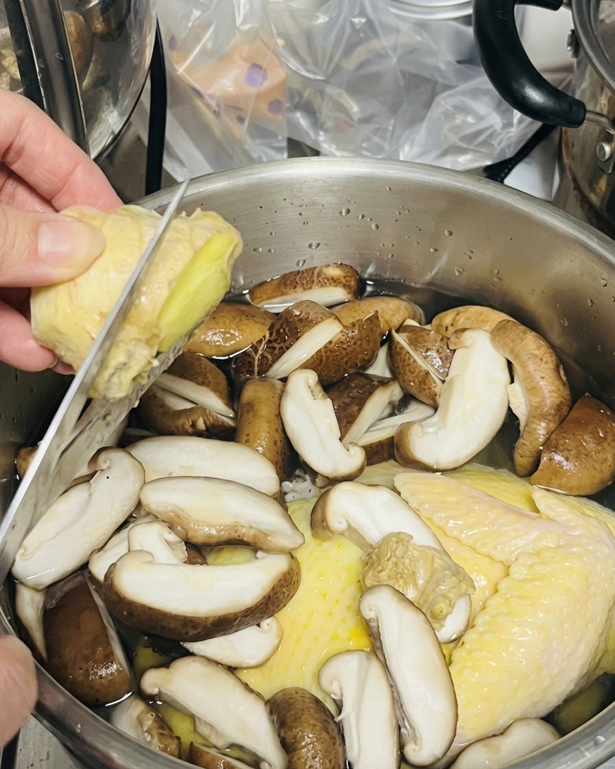 칼로 냄비 위의 생강을 바로 썰어 넣는 모습.