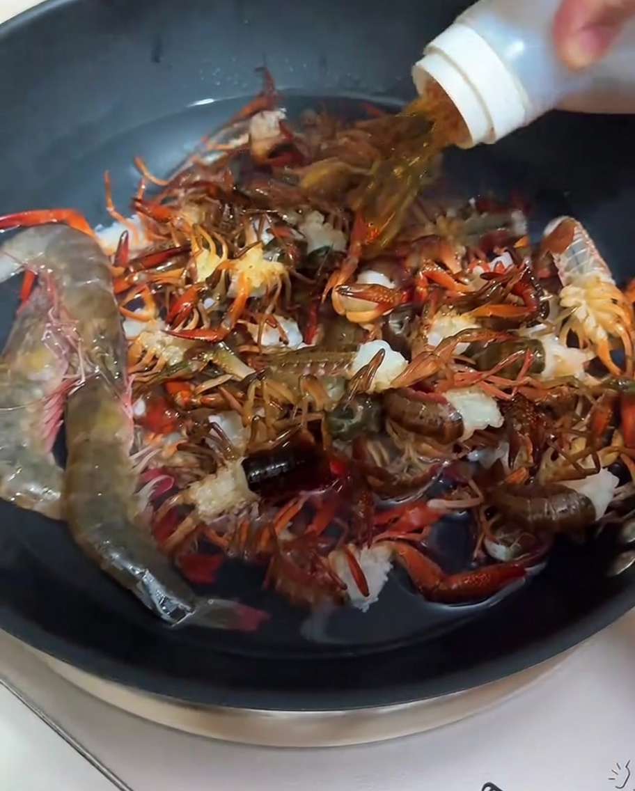 팬에 물과 맛술을 넣고 가재를 데치는 모습.