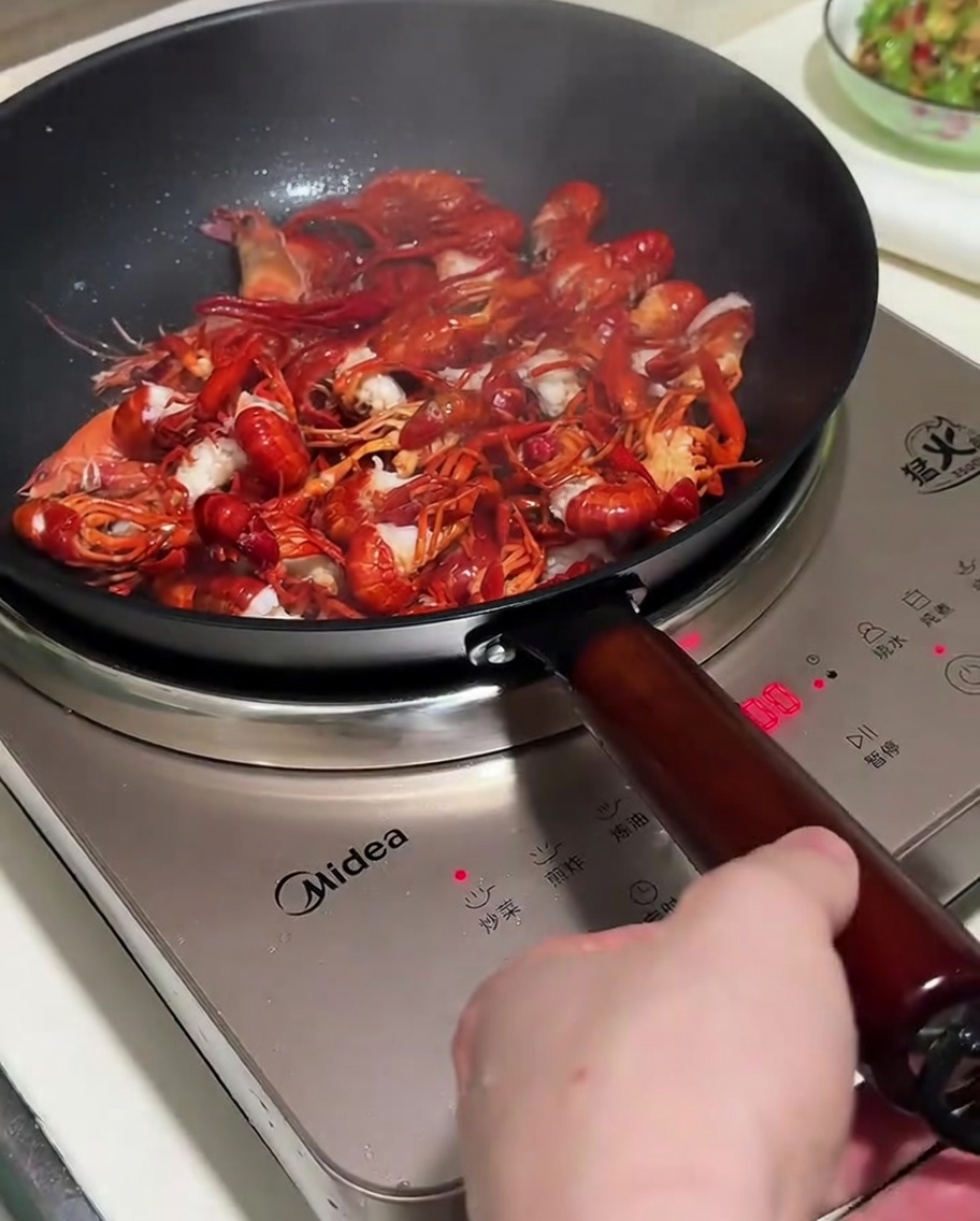 팬에서 가재와 향신 채소를 함께 볶는 모습.