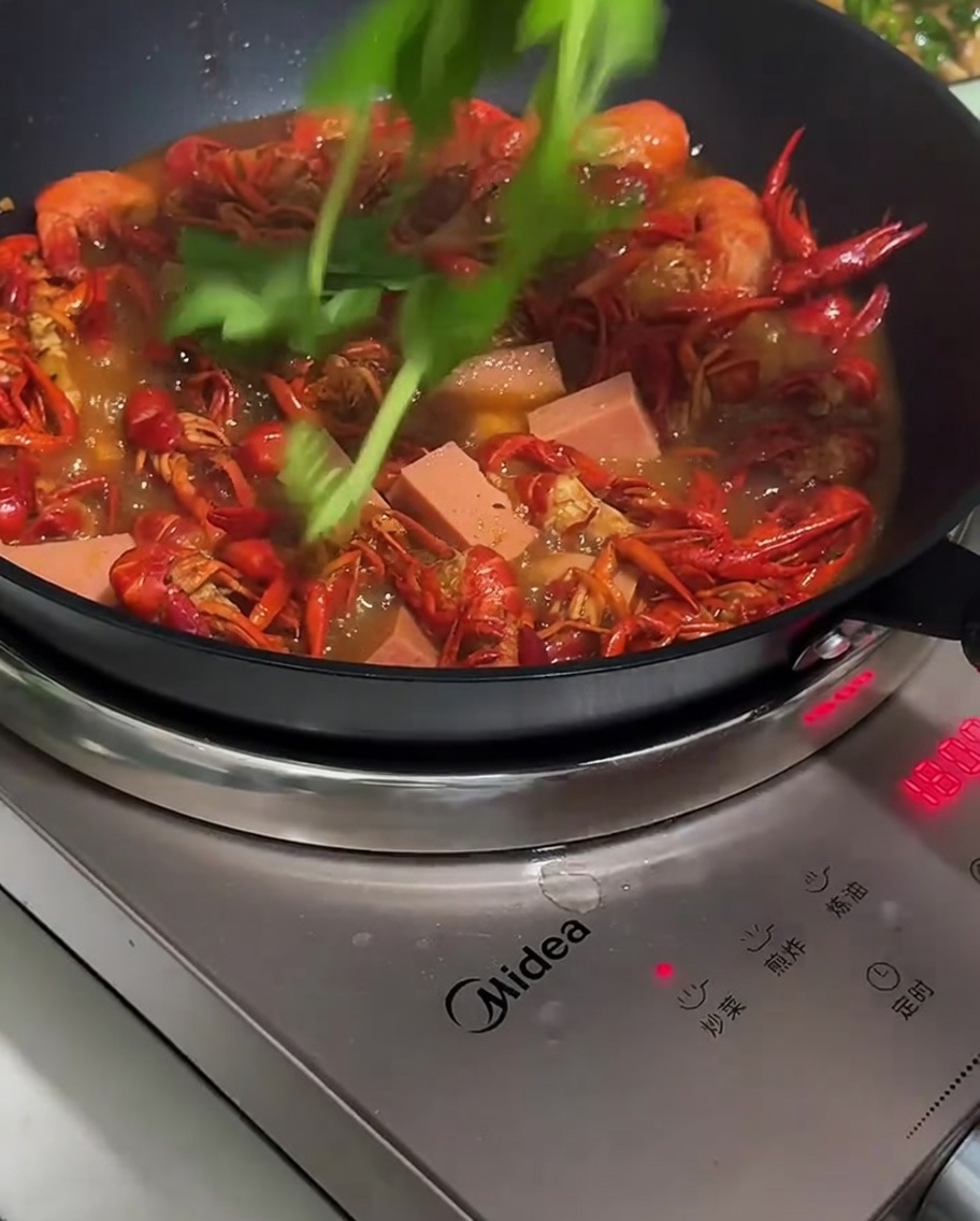 졸여지는 가재에 소시지와 풋고추를 넣는 모습.