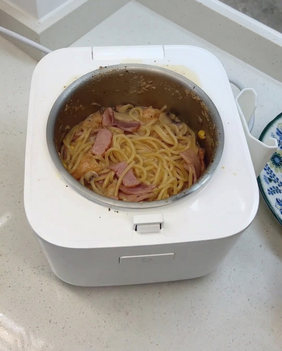 전기밥솥에서 조리가 완료된 후 치즈와 유제품 큐브를 넣고 섞는 모습.