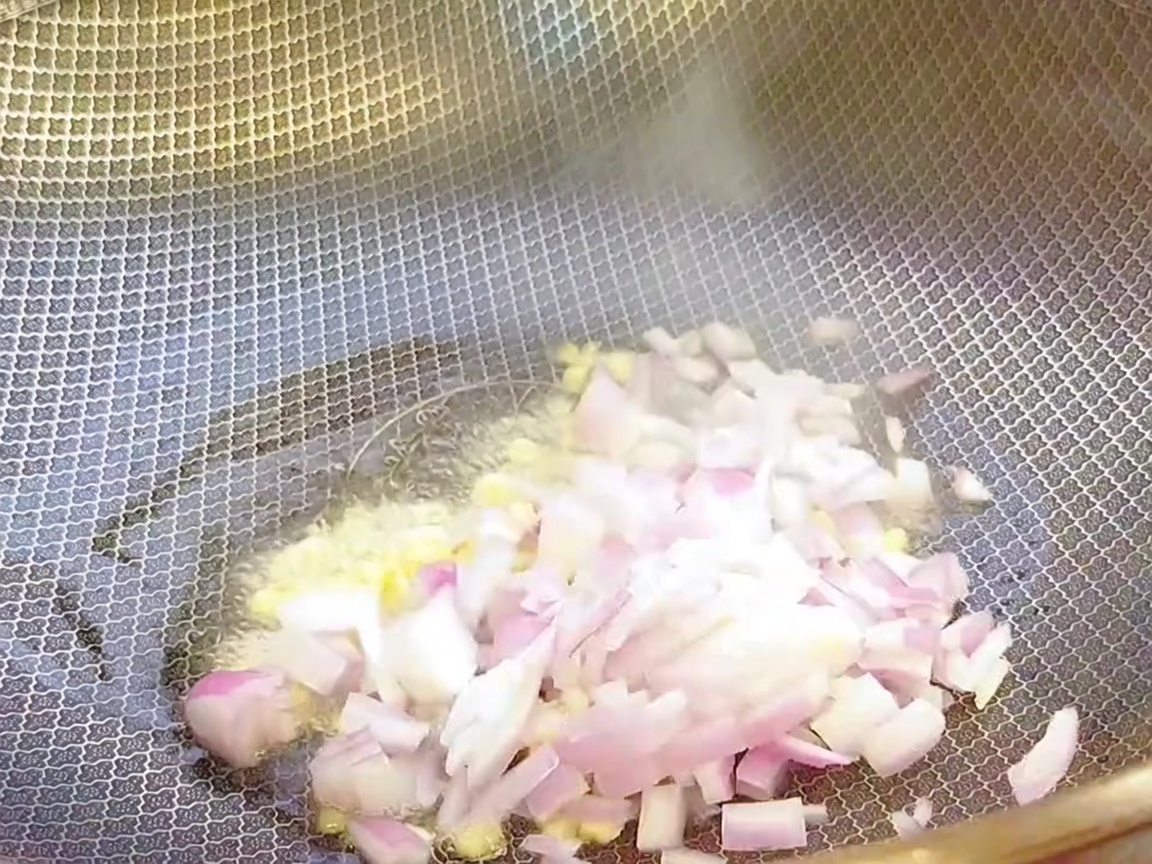 뜨거운 웍에 기름을 두르고 다진 마늘과 다진 양파를 볶는 모습.