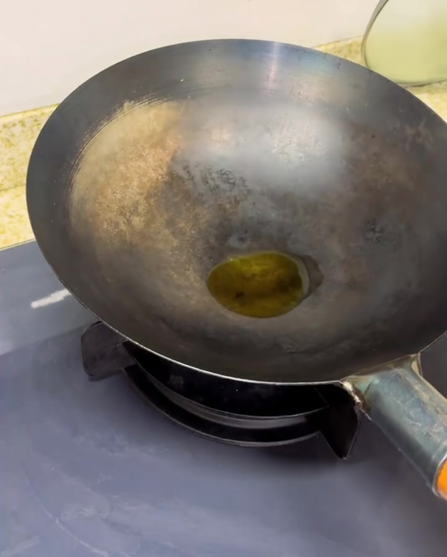 뜨거운 웍에서 다진 토마토가 볶아지며 수분이 날아가는 모습.