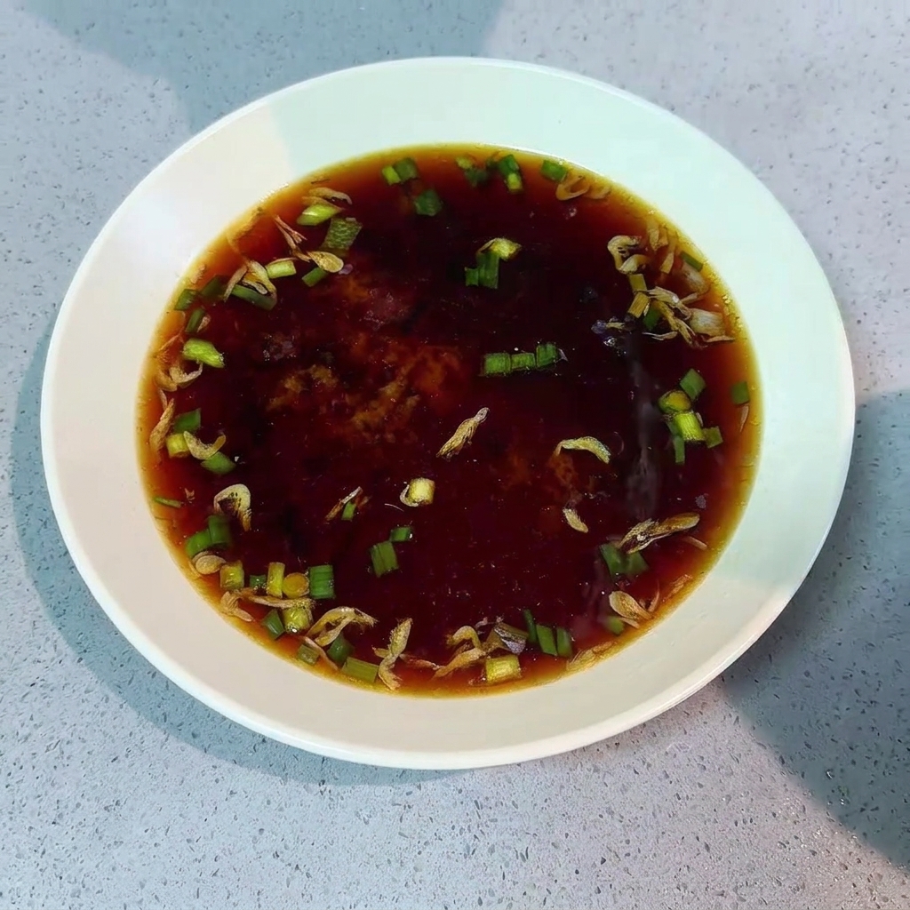 삶아진 국수를 건져 양념 육수가 담긴 그릇에 넣는 모습.