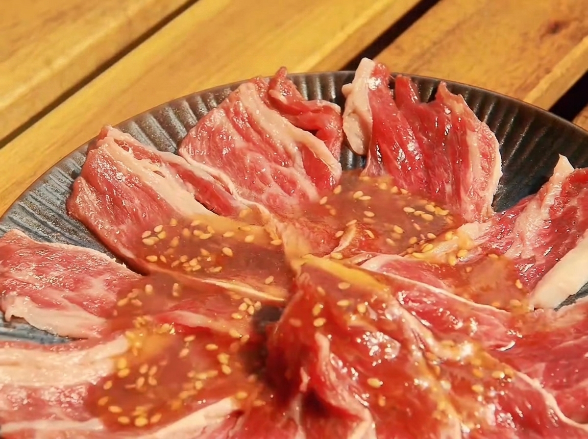 야키니쿠 소스에 버무려진 얇게 썬 소고기가 얕은 접시에 담긴 모습.