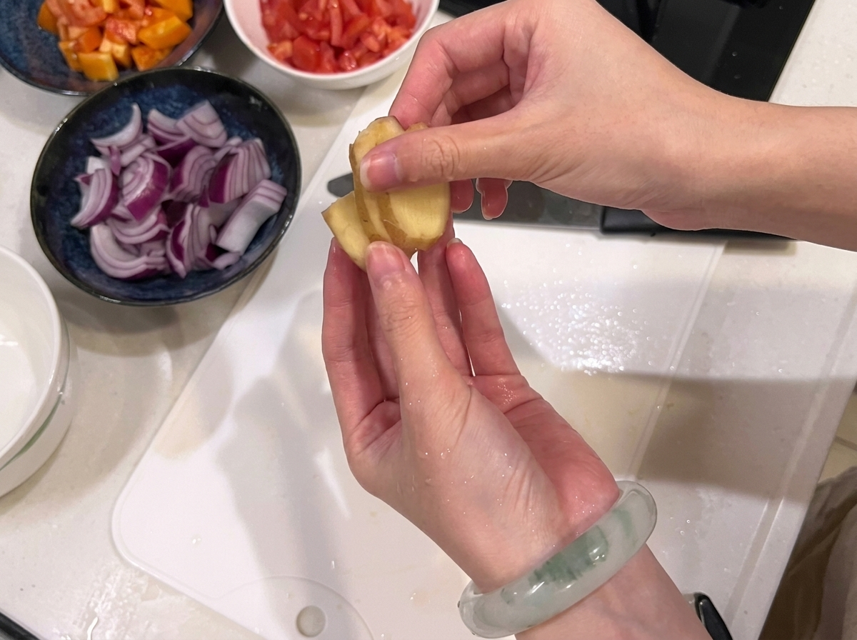 흰 도마 위에서 소고기를 일정한 크기의 큐브 모양으로 썰고 있는 모습.