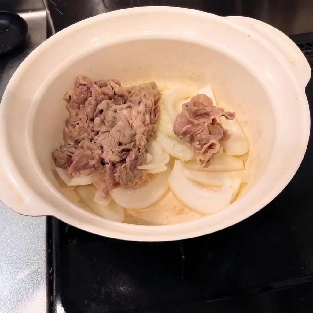 냄비 안에서 볶은 양파와 데친 소고기가 섞이는 모습.