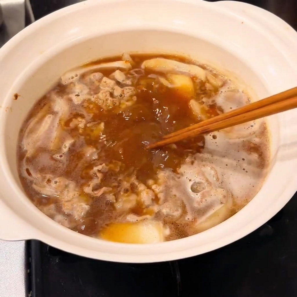 냄비에 고체 카레를 넣고 저어서 걸쭉한 소스를 만드는 모습.