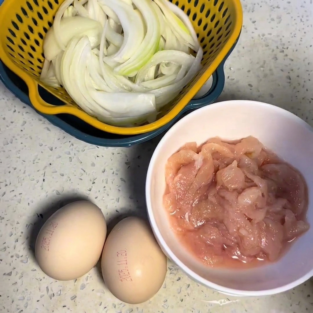 흰 그릇에 담긴 어두운 양념에 버무려진 닭가슴살 조각.