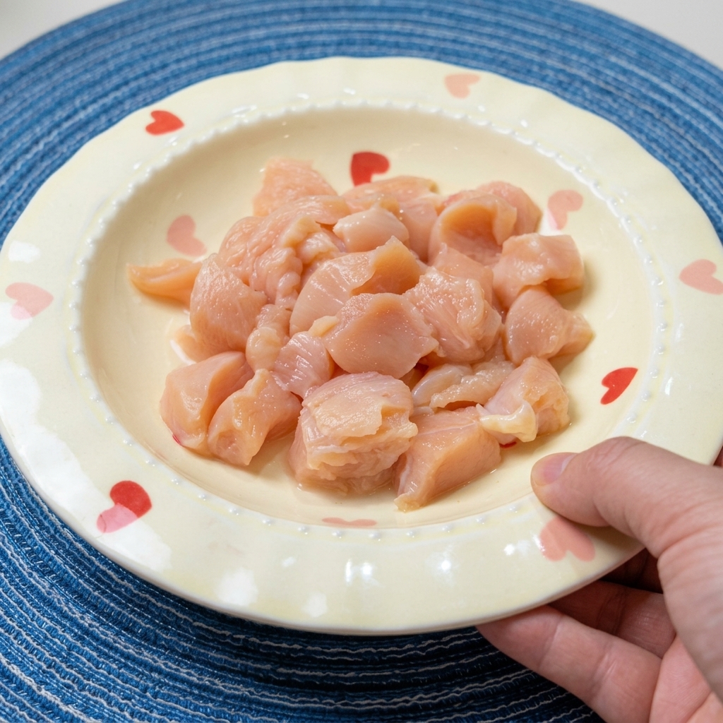 볼에 담긴 깍둑썰기한 생닭가슴살에 간장, 맛술, 향신료를 넣어 양념하는 모습.