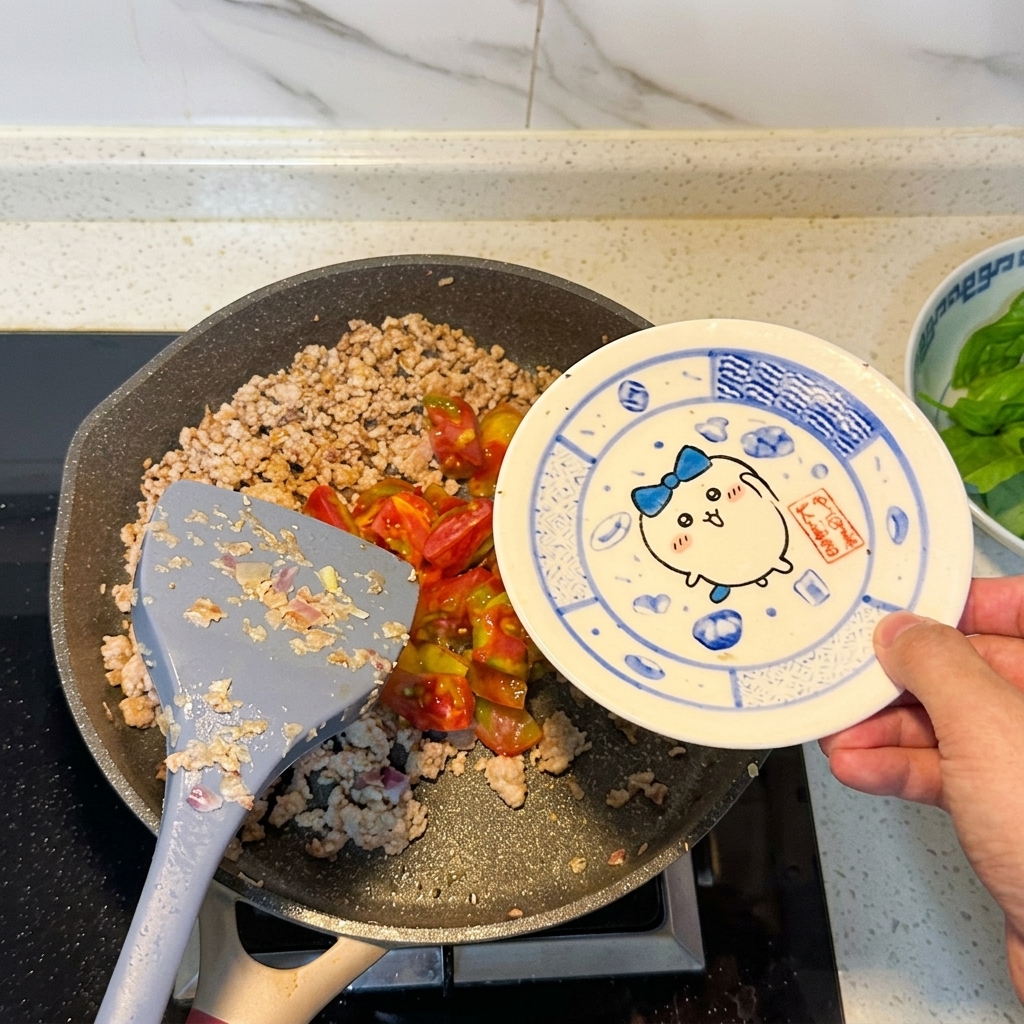 볶은 고기에 잘게 썬 토마토를 넣는 모습