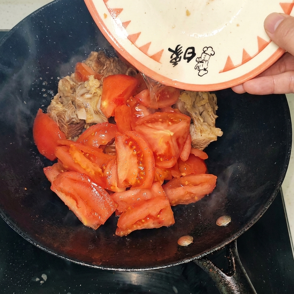 볶은 소갈비에 껍질 벗긴 토마토를 넣는 모습.