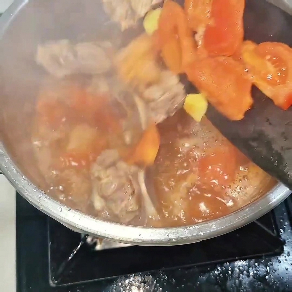 소갈비와 토마토 볶음을 압력솥에 넣고 뚜껑을 닫는 모습.