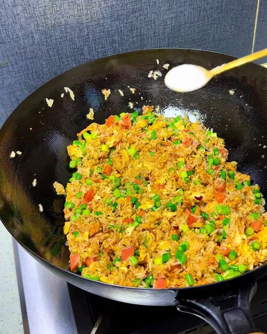 볶음밥 위에 소금과 치킨스톡을 뿌리는 모습.