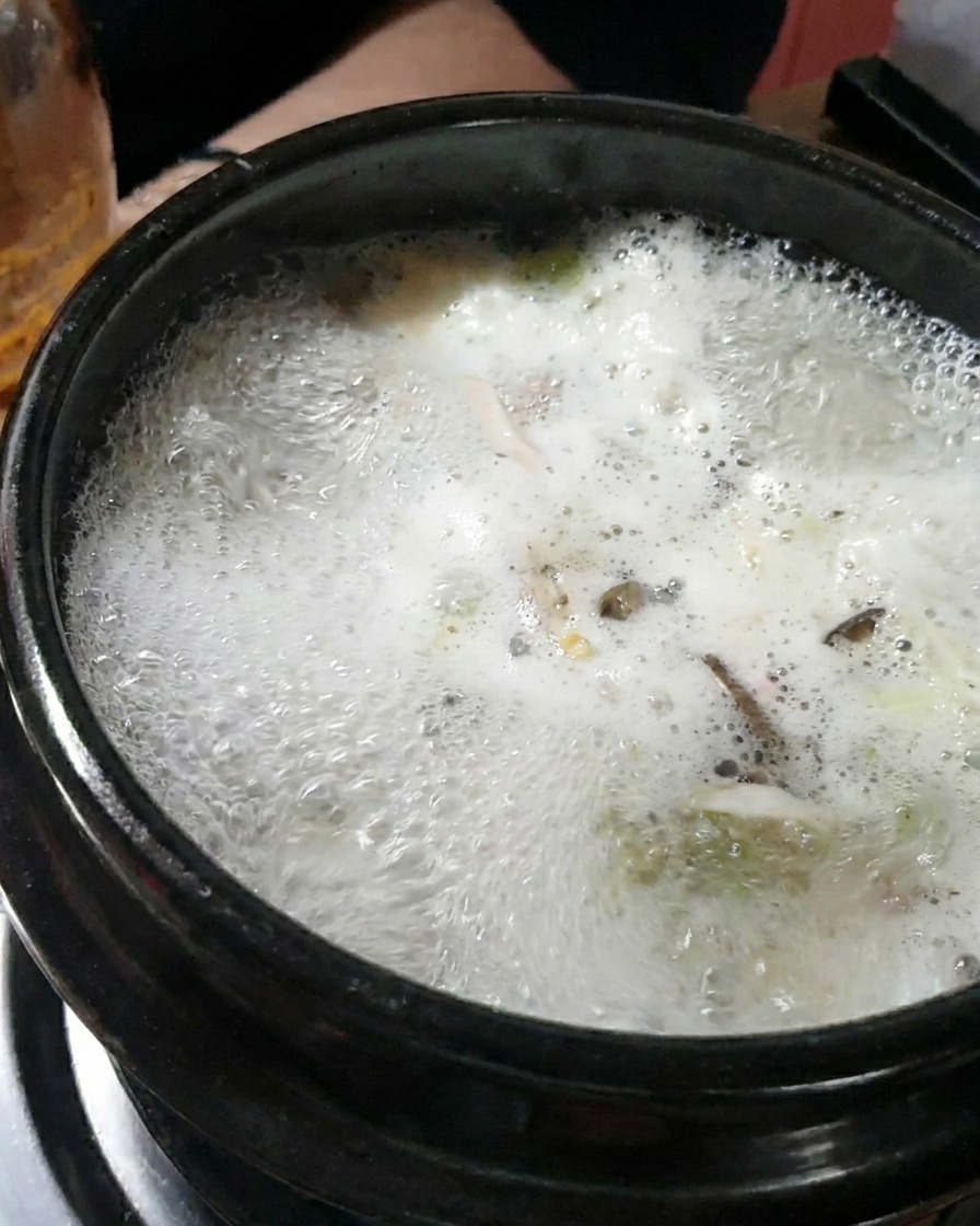 끓는 육수에 된장을 크게 한 스푼 떠서 넣고 푸는 모습.