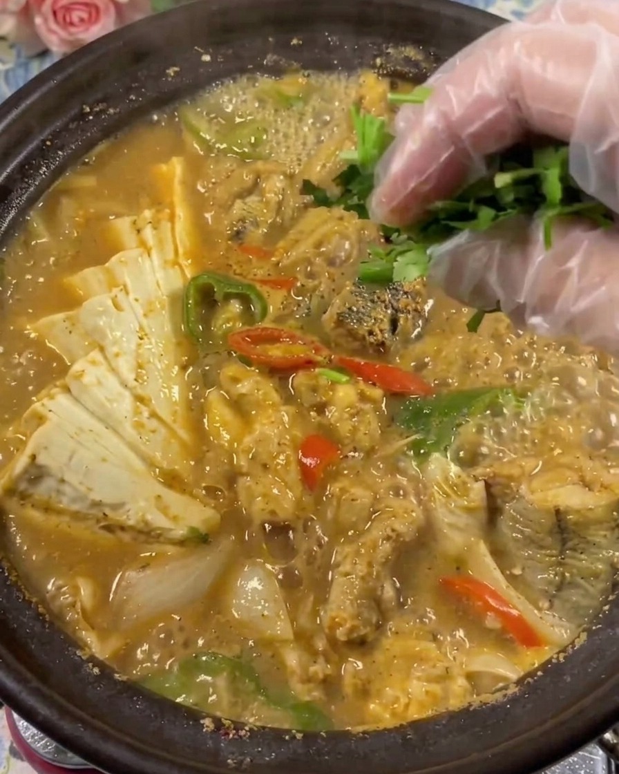 보글거리는 뚝배기 위에 고수를 올리는 모습.