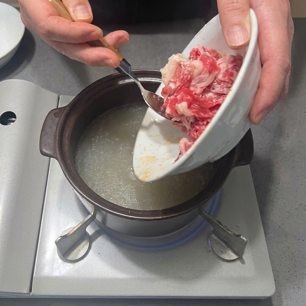 육수가 끓는 냄비에 차돌박이를 넣는 모습.