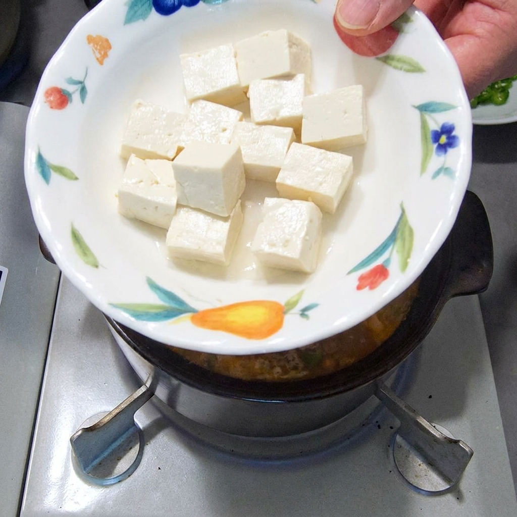 깍둑썰기한 두부를 찌개에 넣는 모습.