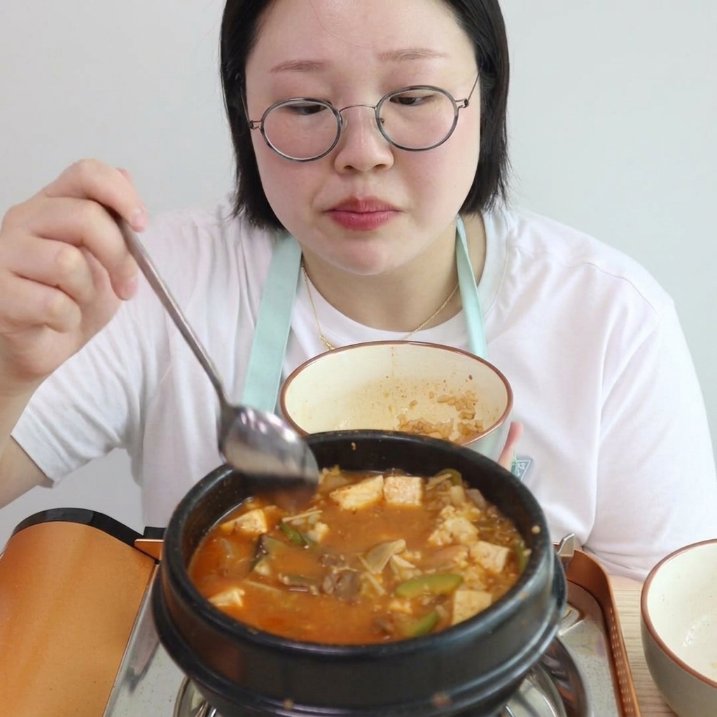 끓는 찌개에 밥을 넣어 섞는 모습.