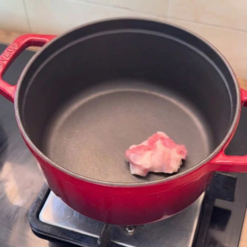예열된 냄비에 삼겹살, 양파, 다진 마늘을 넣는 모습.