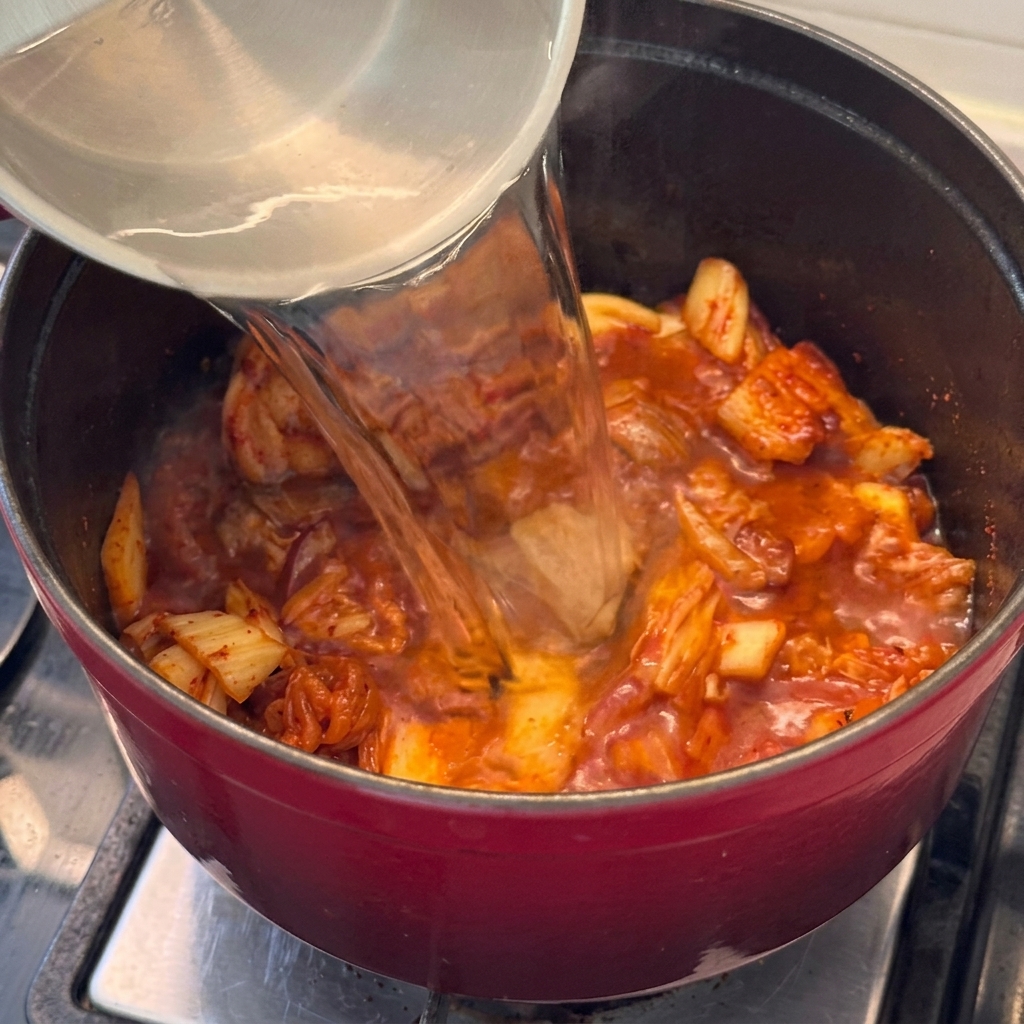 볶은 재료에 물을 붓고 찌개 베이스를 만드는 모습.