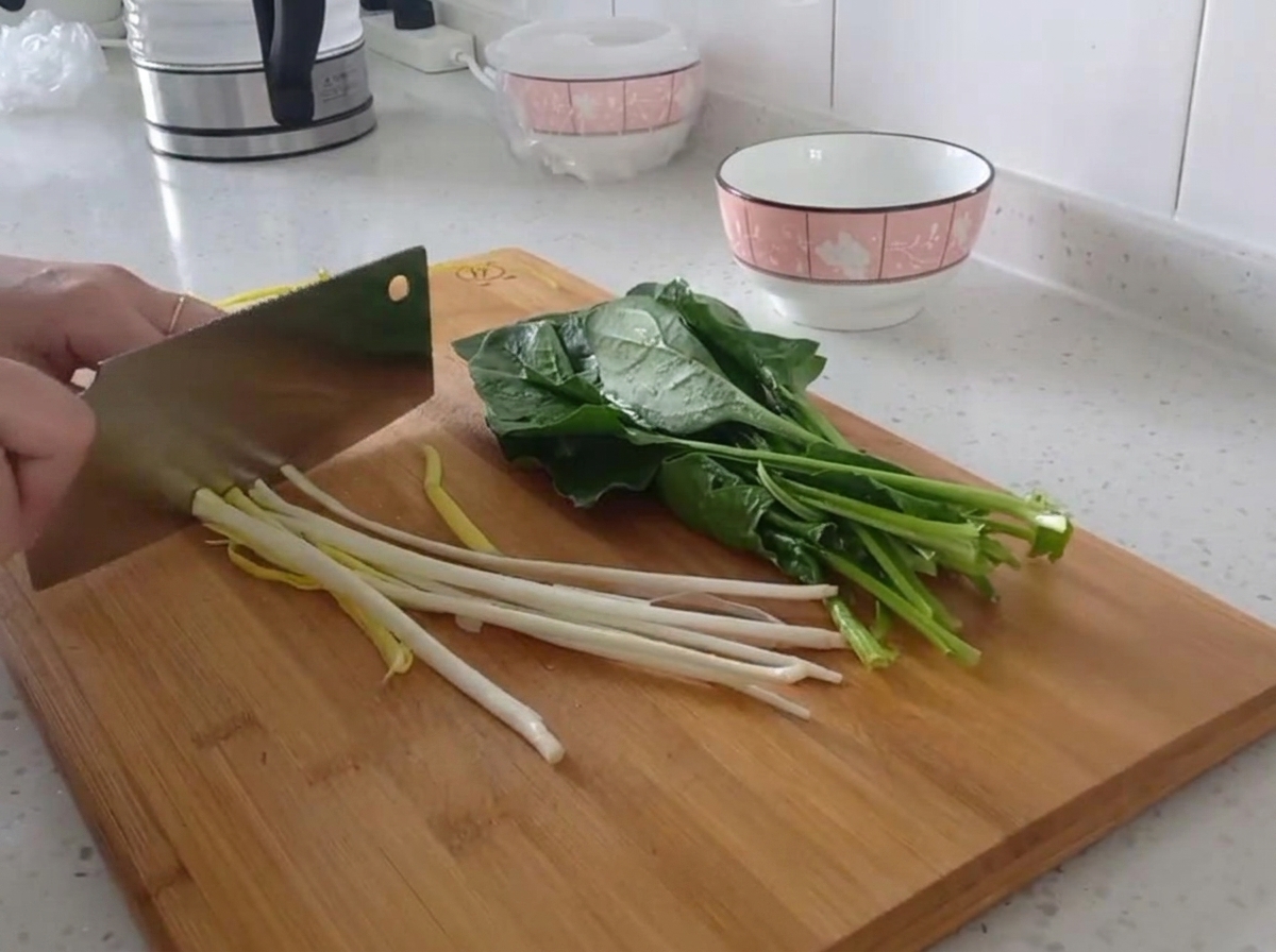 도마 위에서 파를 일정한 크기로 송송 써는 모습.