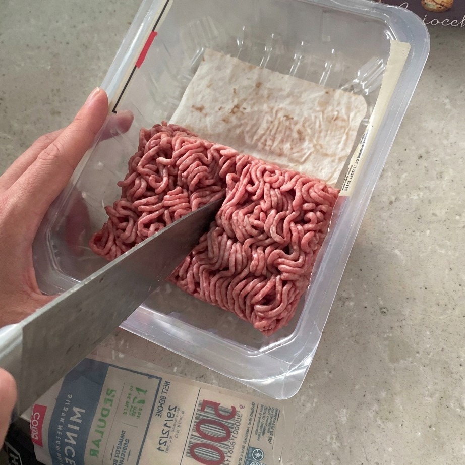 마트 포장 상태의 소고기 다짐육을 칼로 이등분하는 모습.