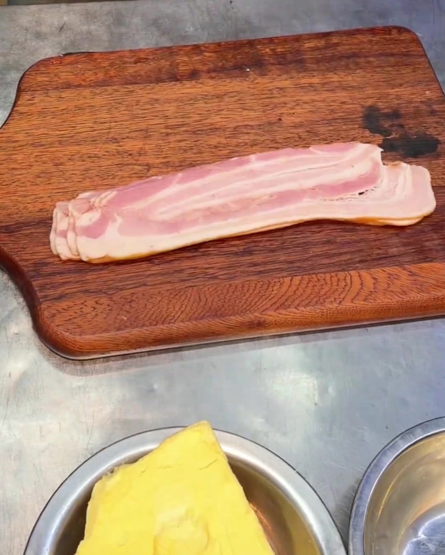 나무 도마 위에 올려진 훈연 베이컨 조각들.