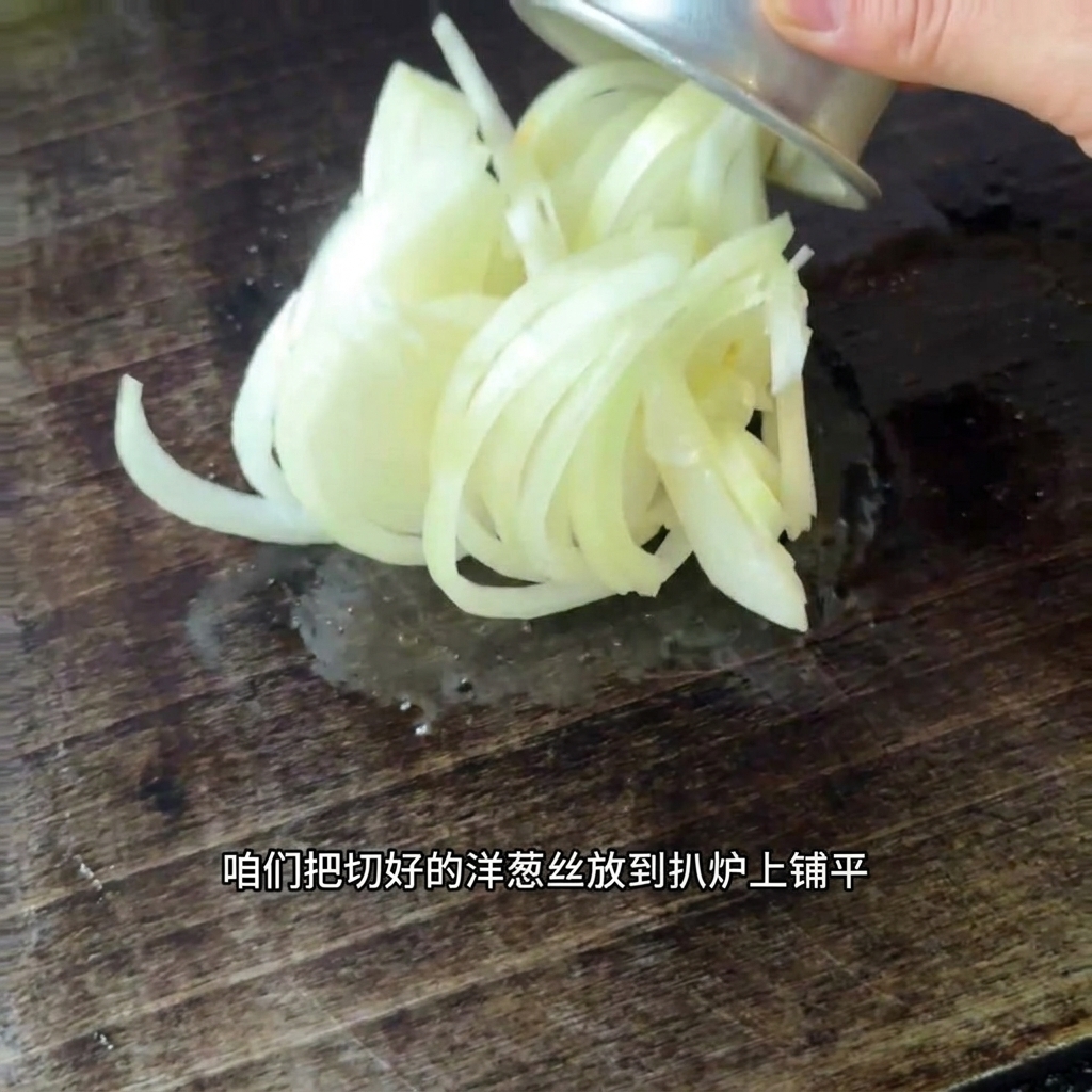 뜨거운 그리들 표면에 채썬 양파를 고르게 펼치는 모습.