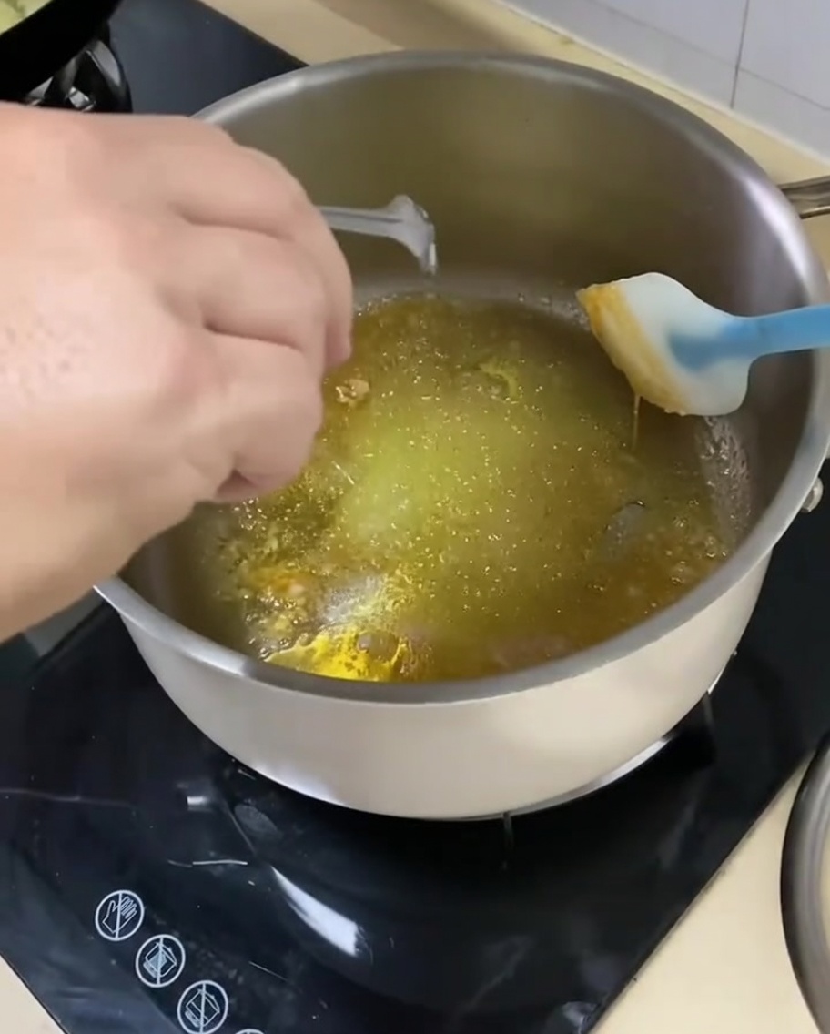 카라멜화된 설탕 베이스와 양념에 썰어둔 양파를 넣고 볶는 모습.