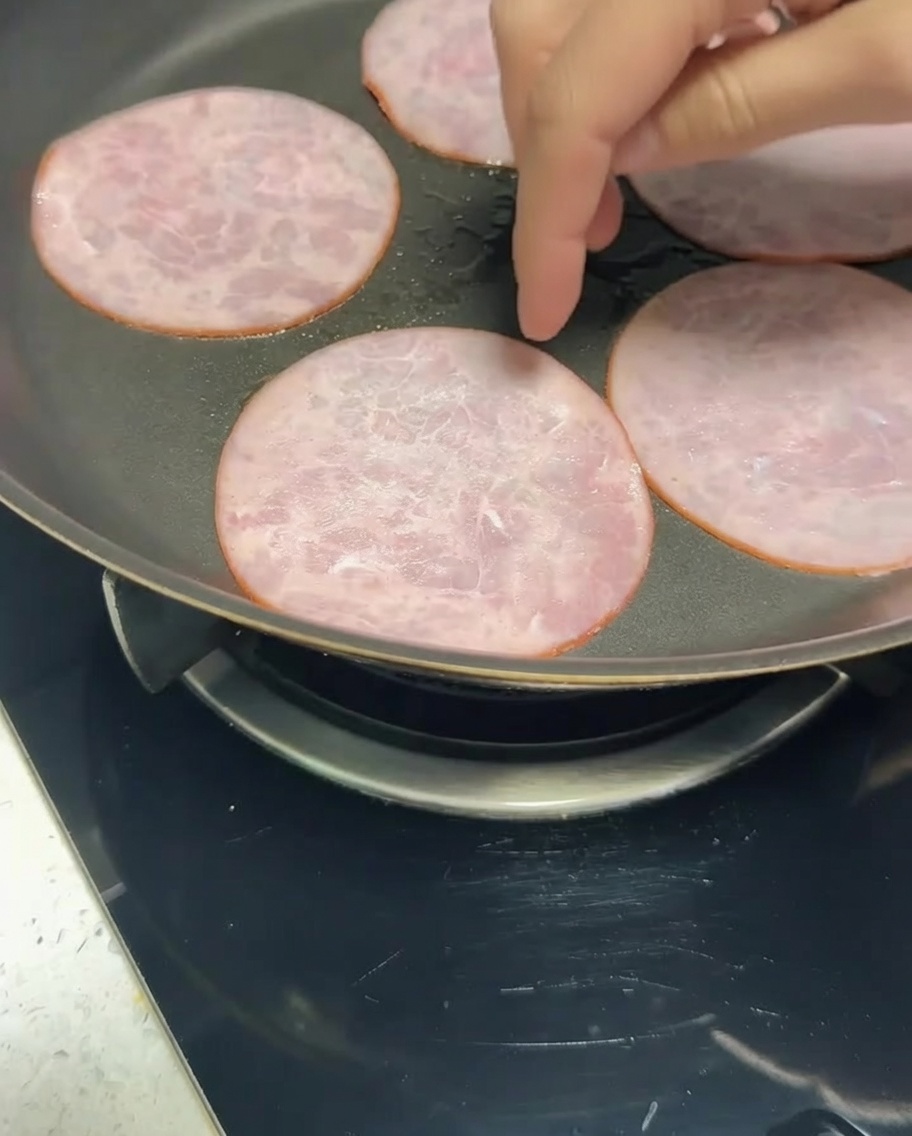 팬 위에서 노릇하게 구워지고 있는 저지방 베이컨 슬라이스.