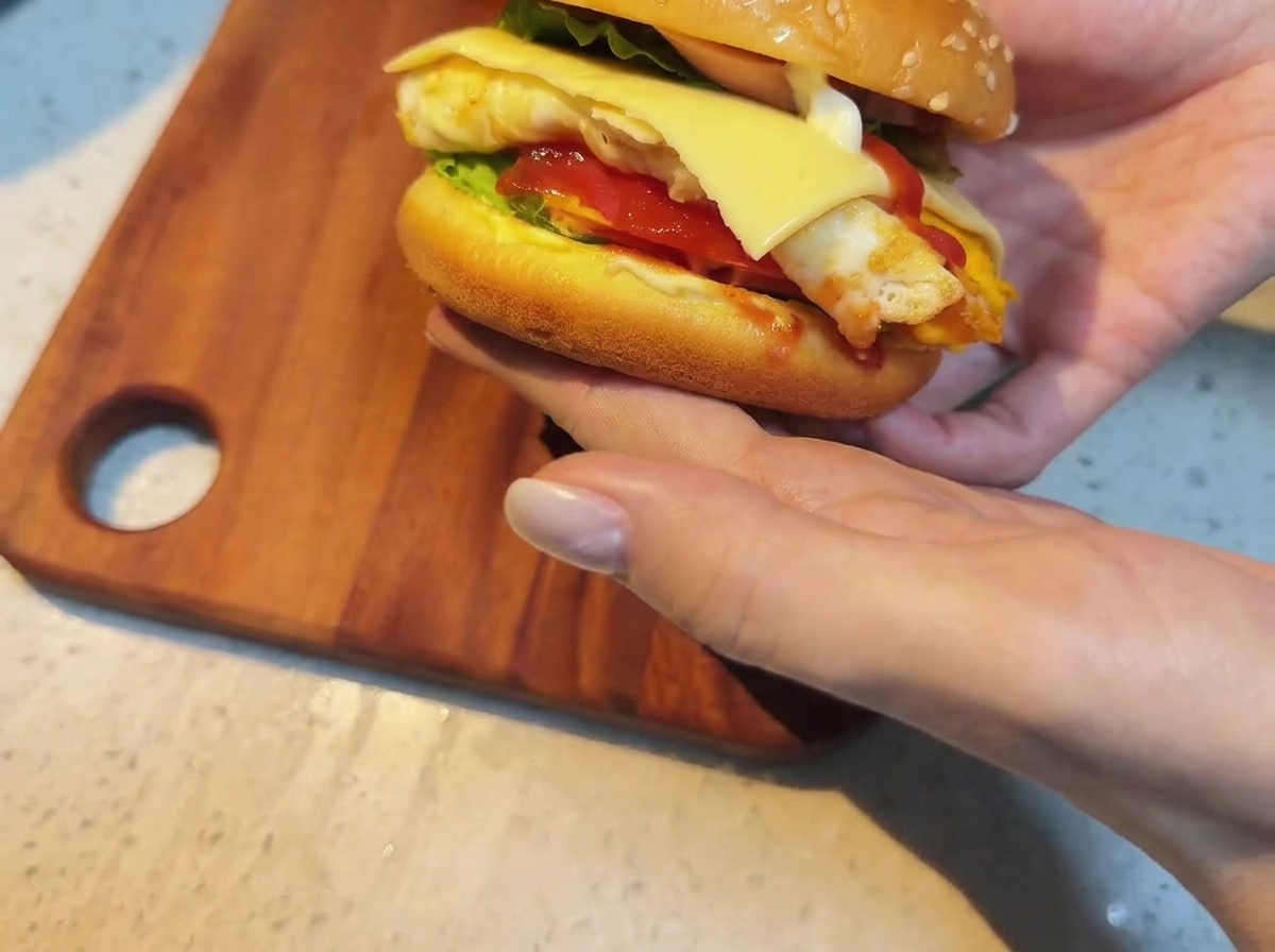 조립된 재료들 위로 올려진 치즈 슬라이스.