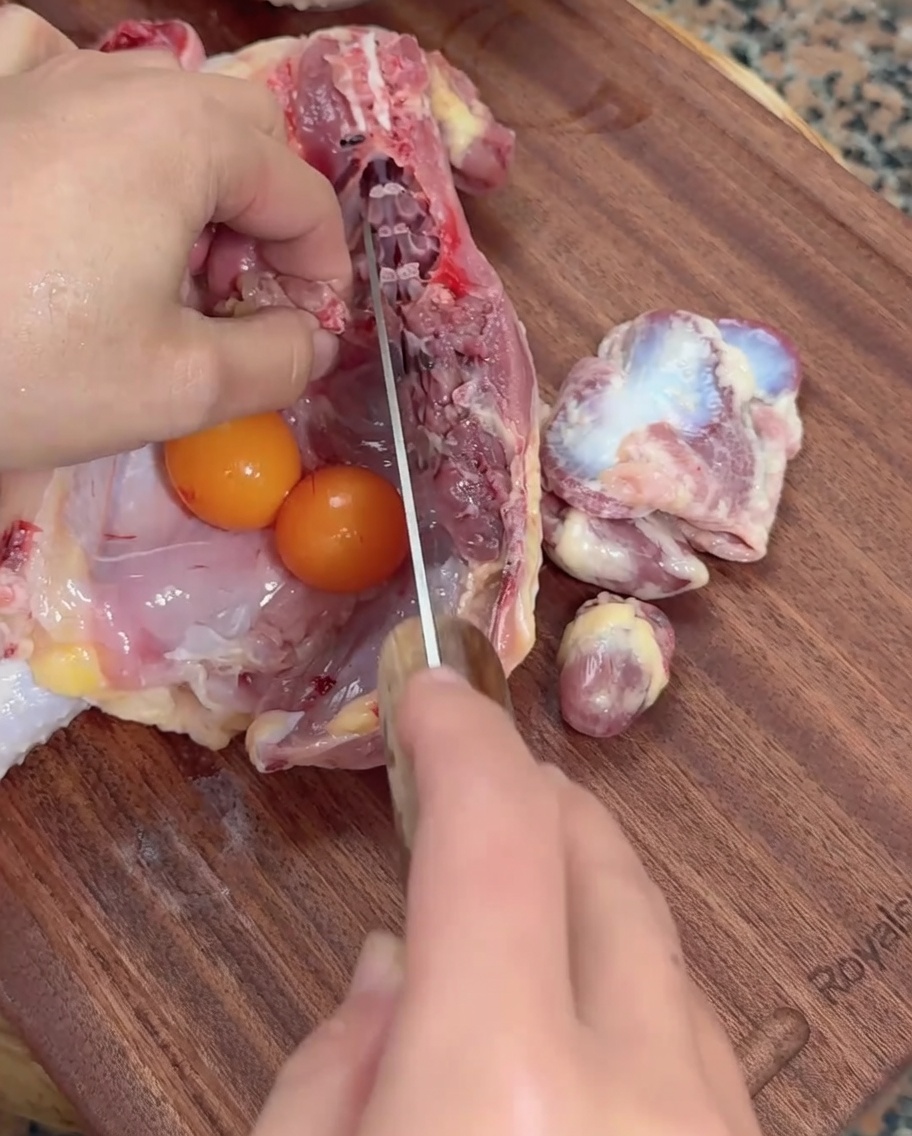 도마 위에서 식도로 닭 내장을 손질하는 모습.