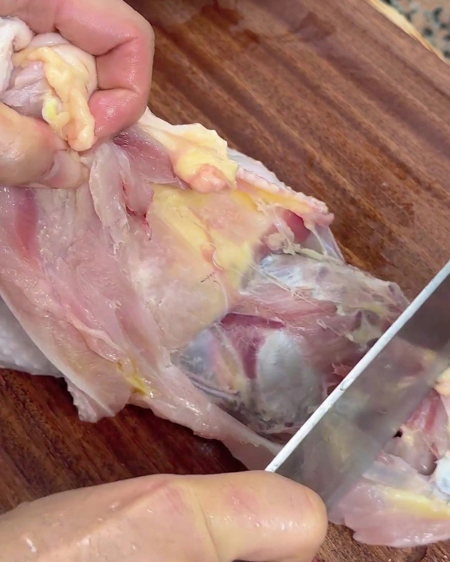 날카로운 칼로 닭 뼈에서 살을 발라내는 모습.