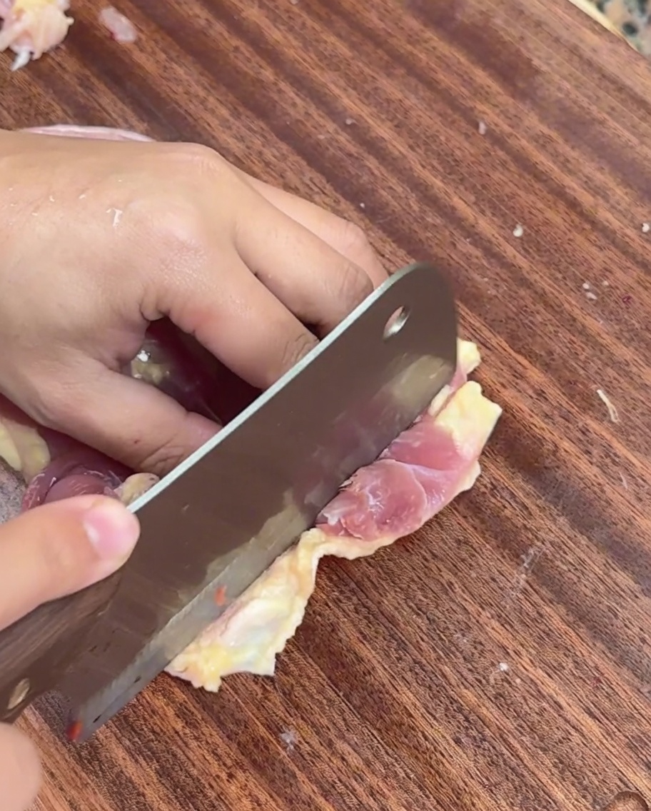 도마 위에서 발골한 닭 살을 얇게 저미는 모습.