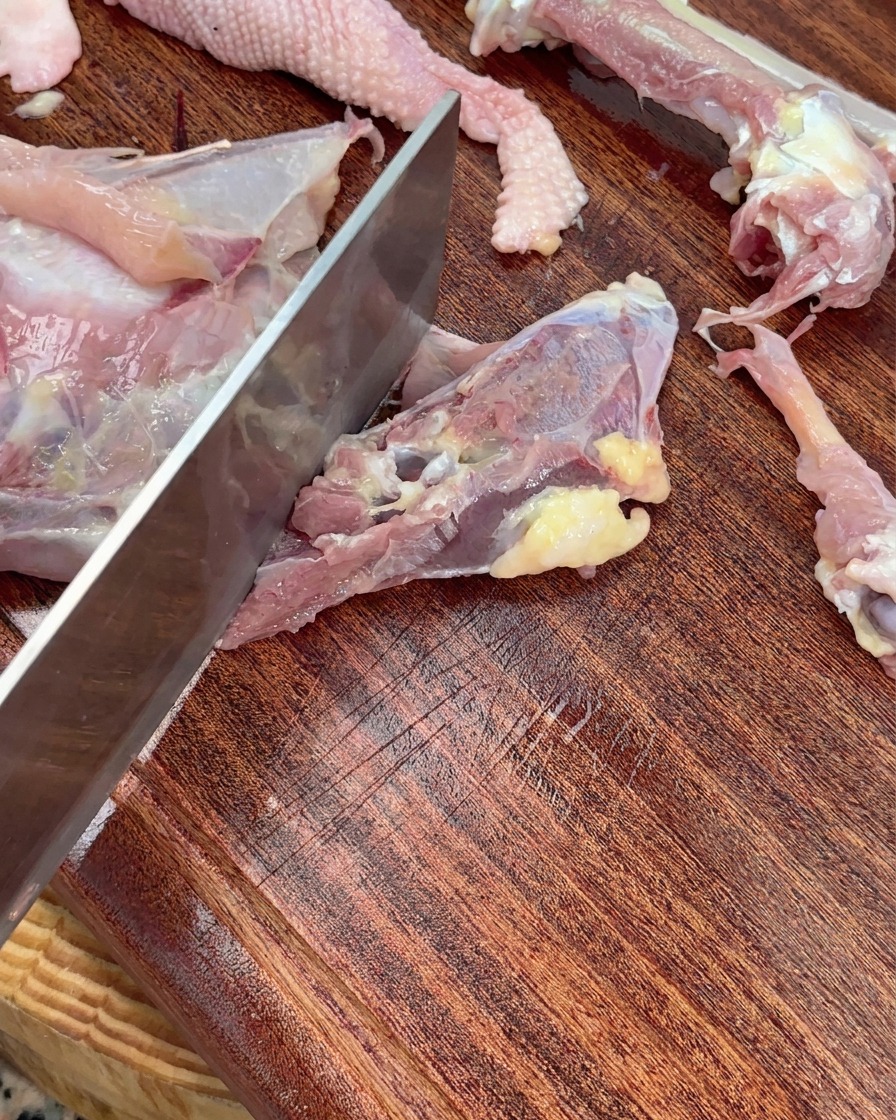 칼로 닭 뼈를 크게 토막 내는 모습.