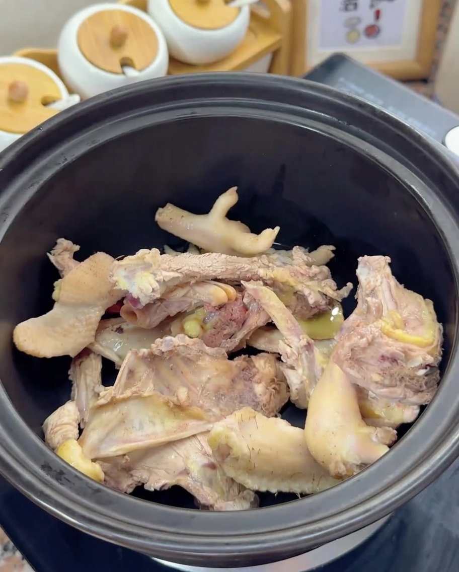 검은색 옹기 바닥에 데친 닭 뼈가 담긴 모습.