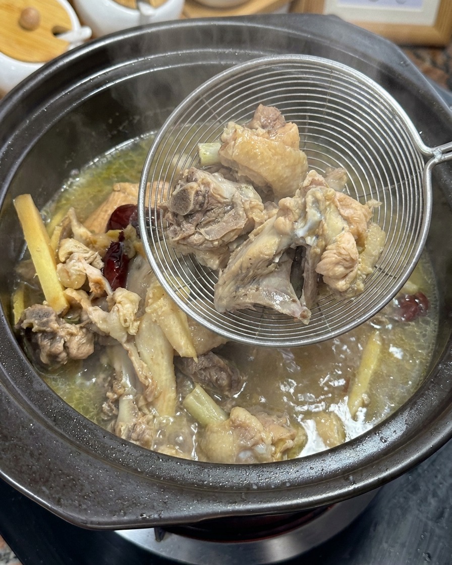 망 국자로 육수에서 뼈와 약재를 건져내는 모습.