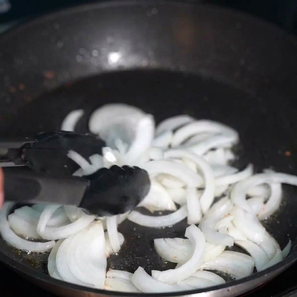 베이컨 기름에 투명하게 볶아지는 채 썬 양파.