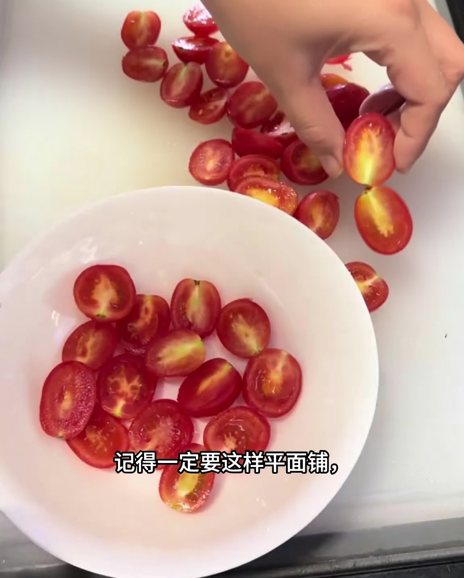 흰색 그릇에 평평하게 잘 배열된 반으로 자른 체리 토마토들.