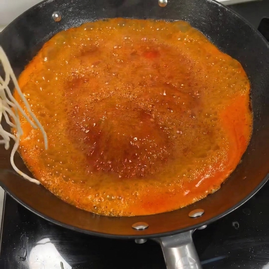 토마토 육수에 면을 넣어 끓이는 모습.