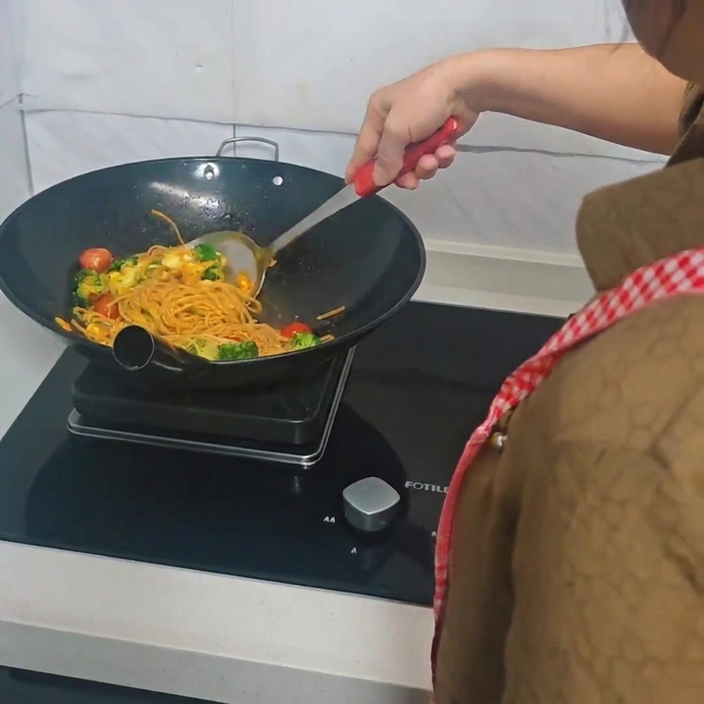 주걱을 사용해 웍 안의 모든 재료를 골고루 볶고 있는 모습.