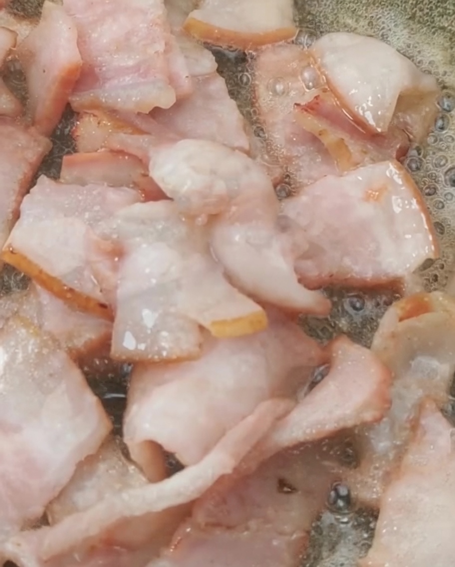노릇하게 볶아진 베이컨에 토마토를 넣는 모습