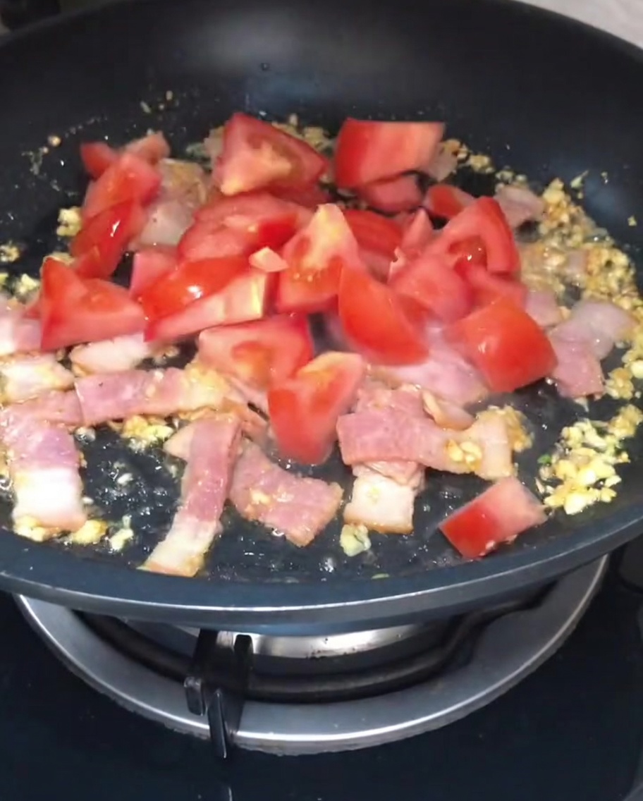 볶아진 마늘과 베이컨 위에 추가되는 신선한 깍둑썰기 토마토.