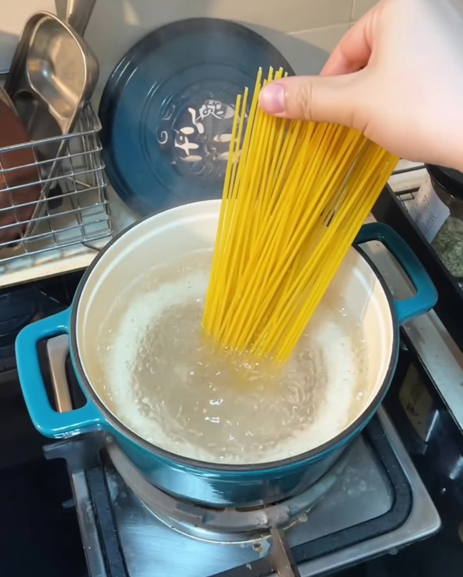끓는 물에 스파게티 면을 넣는 모습.